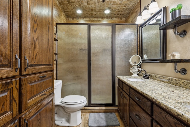 bathroom featuring vanity, toilet, and walk in shower