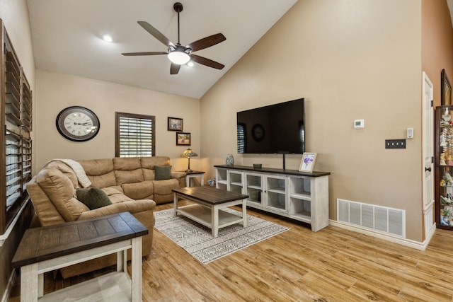 living room featuring high vaulted ceiling, light hardwood / wood-style floors, and ceiling fan