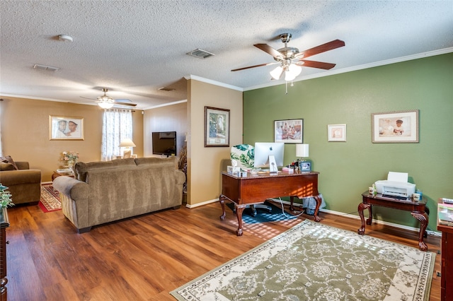 home office featuring visible vents, ceiling fan, ornamental molding, wood finished floors, and a textured ceiling