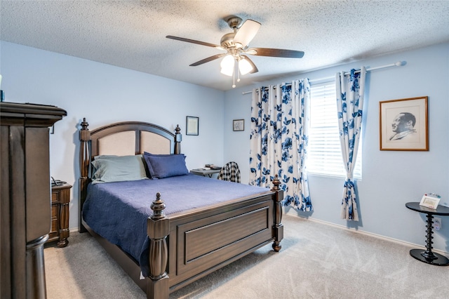 bedroom with light carpet, a textured ceiling, a ceiling fan, and baseboards