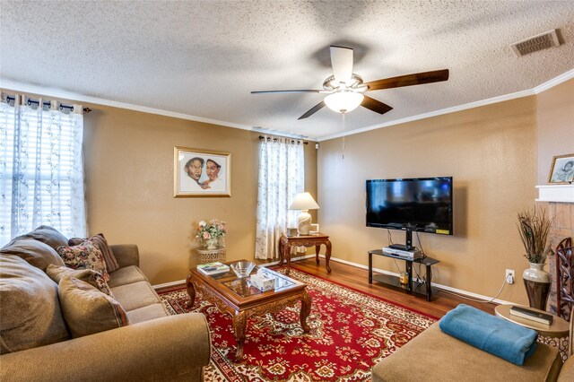 living room with ornamental molding, plenty of natural light, wood finished floors, and visible vents