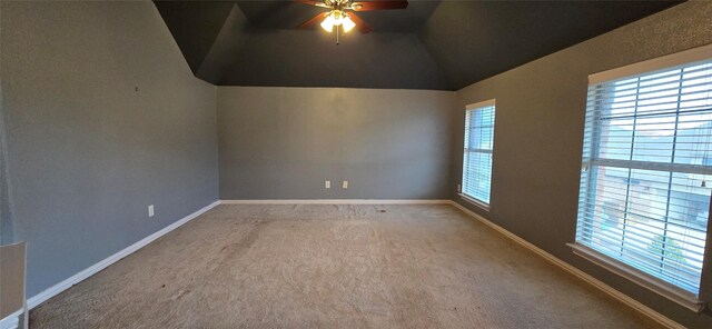 empty room with carpet flooring, vaulted ceiling, and ceiling fan