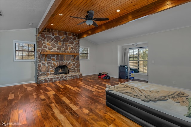 unfurnished bedroom featuring hardwood / wood-style flooring, ceiling fan, a fireplace, lofted ceiling with beams, and wooden ceiling