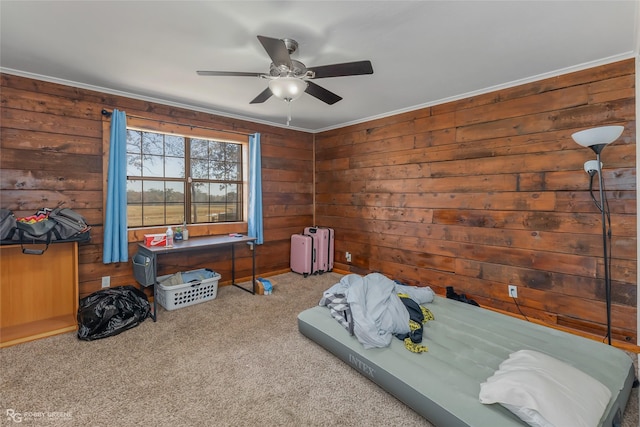 bedroom featuring ceiling fan, ornamental molding, carpet, and wood walls