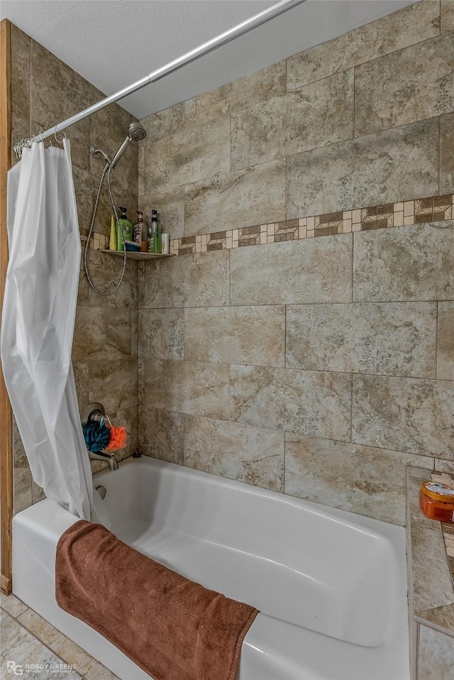 bathroom featuring shower / bath combo and a textured ceiling