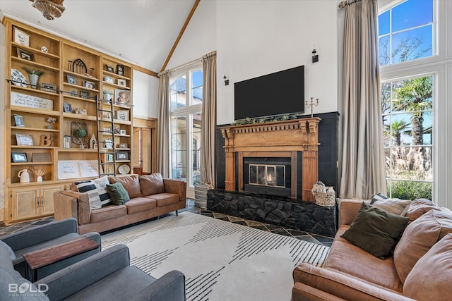 interior space featuring a stone fireplace, carpet floors, and high vaulted ceiling