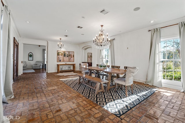 dining area with crown molding and a notable chandelier