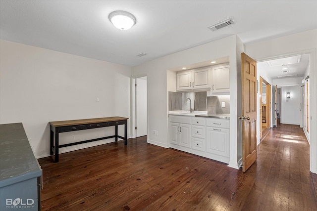 kitchen featuring white cabinetry, dark wood-type flooring, sink, and decorative backsplash