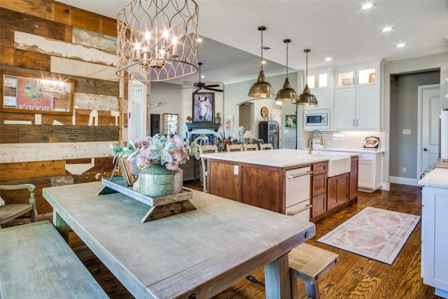 kitchen with sink, dark hardwood / wood-style flooring, white cabinetry, and a kitchen island with sink