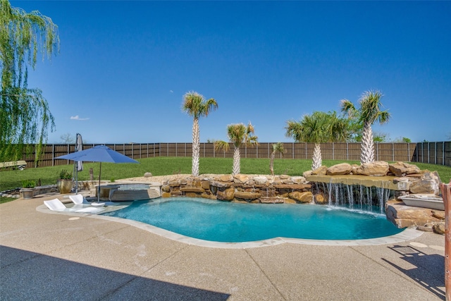 view of swimming pool featuring a lawn, pool water feature, a patio, and an in ground hot tub