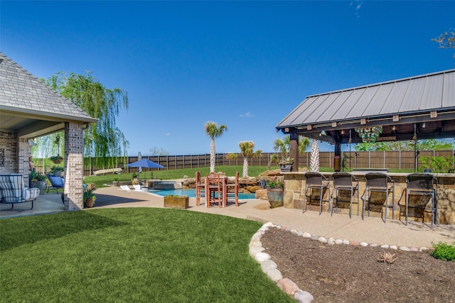 view of yard with a fenced in pool, a bar, and a patio