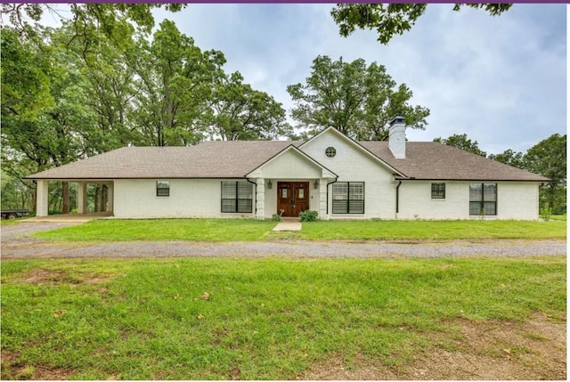 ranch-style house featuring a front lawn and a carport