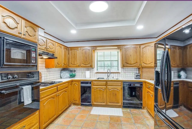 kitchen with black appliances, backsplash, a raised ceiling, and sink