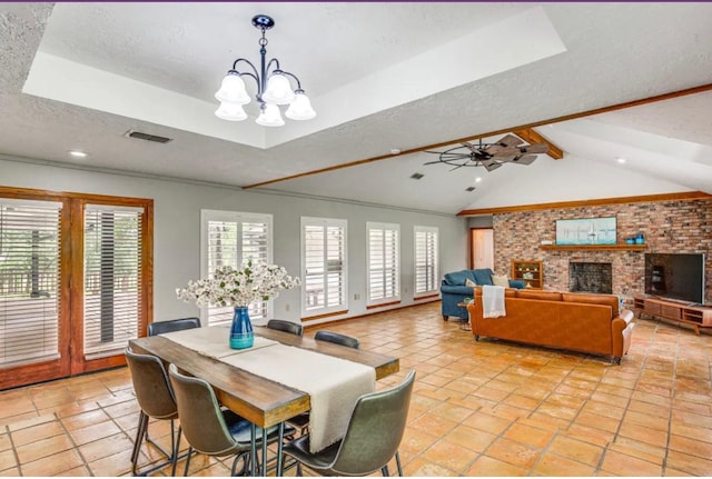 dining space featuring vaulted ceiling with beams, a healthy amount of sunlight, a textured ceiling, and ceiling fan with notable chandelier