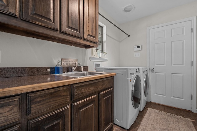 laundry room with cabinets, independent washer and dryer, dark tile patterned floors, and sink