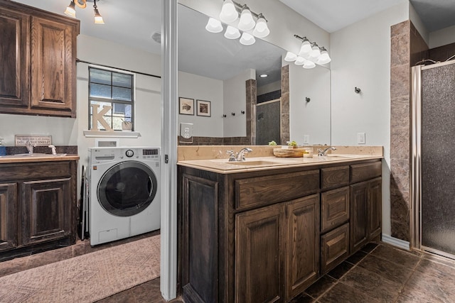 bathroom featuring tile patterned flooring, vanity, a shower with door, and washer / clothes dryer