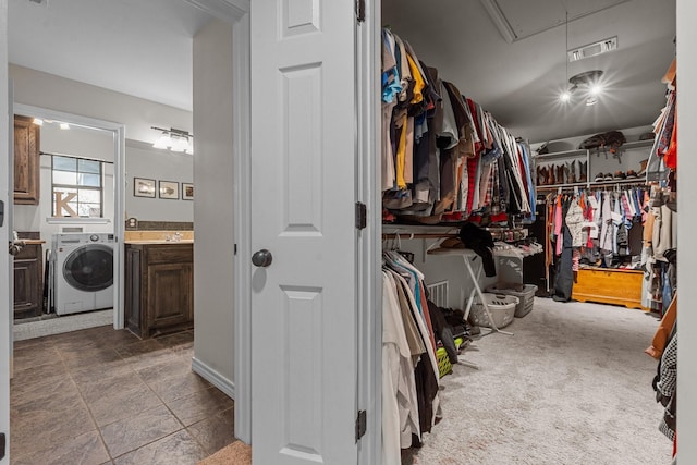 spacious closet featuring washer / dryer and carpet floors