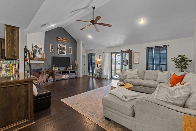 living room featuring ceiling fan, dark hardwood / wood-style flooring, a fireplace, and high vaulted ceiling