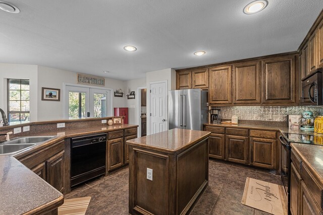 kitchen with sink, french doors, decorative backsplash, a kitchen island, and black appliances