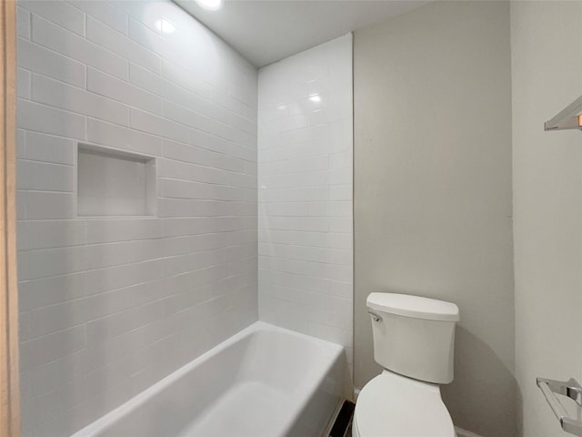 bathroom with tiled shower / bath combo and toilet