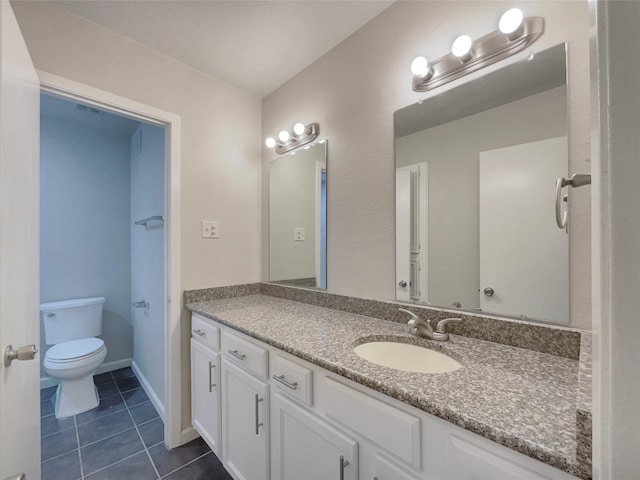 bathroom featuring tile patterned flooring, vanity, and toilet