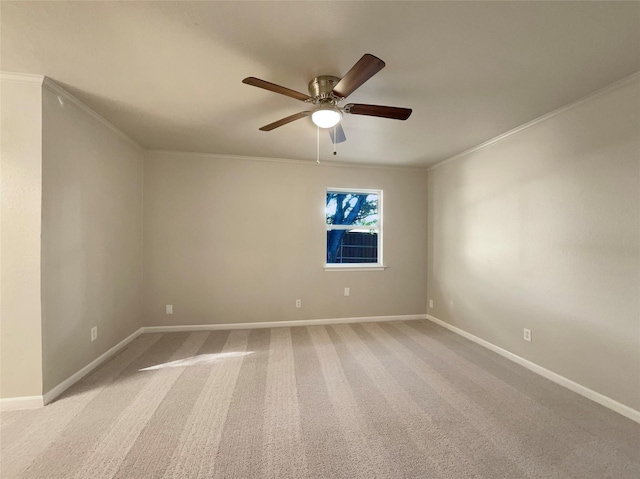 carpeted empty room with ceiling fan and crown molding