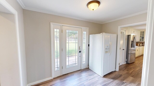 doorway with crown molding and light wood-type flooring