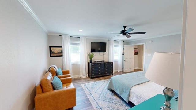 bedroom featuring hardwood / wood-style floors, ceiling fan, and crown molding