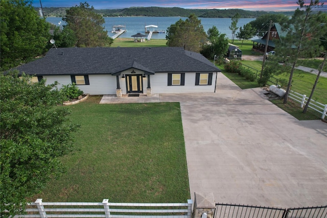 view of front of property featuring a water view and a lawn