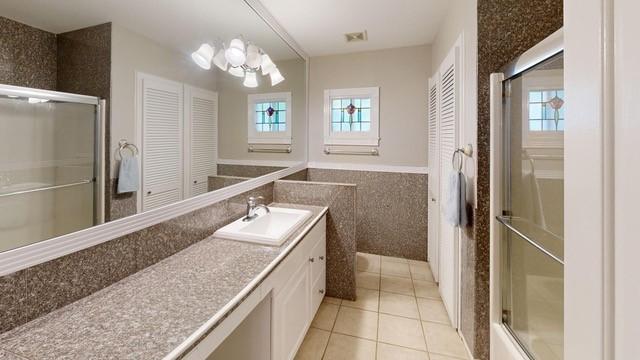 bathroom with vanity, tile patterned floors, and tile walls