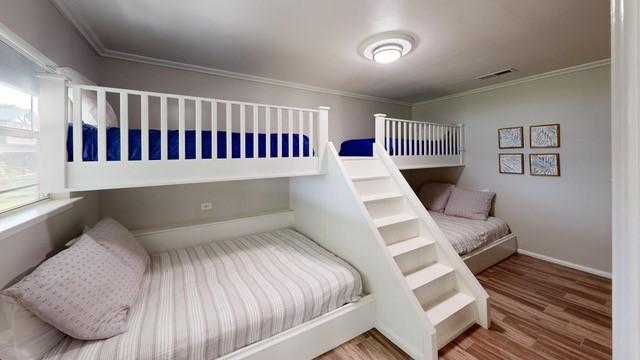 bedroom featuring wood-type flooring and crown molding