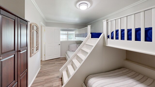 bedroom with crown molding and light hardwood / wood-style floors