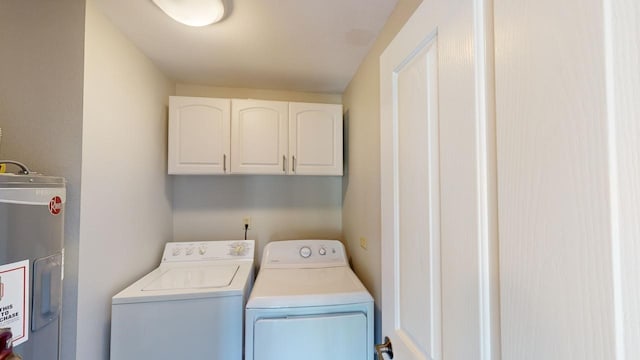 laundry room featuring cabinets, electric water heater, and washing machine and clothes dryer