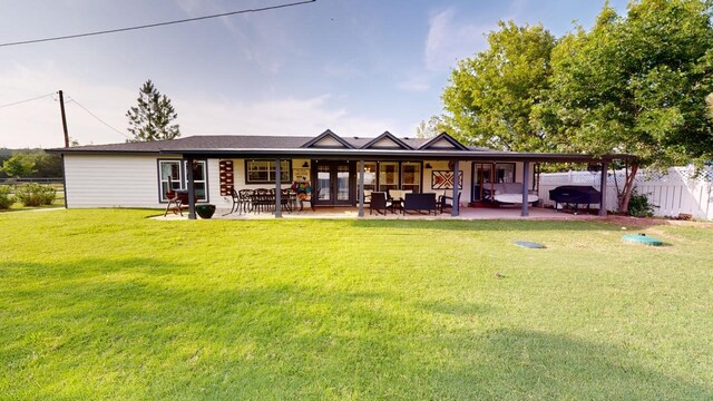 back of house featuring a patio area and a lawn