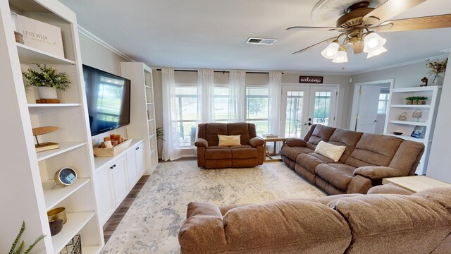 living room featuring a wealth of natural light, crown molding, ceiling fan, and hardwood / wood-style flooring