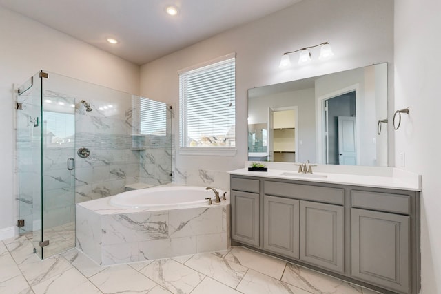 bathroom with vanity and shower with separate bathtub