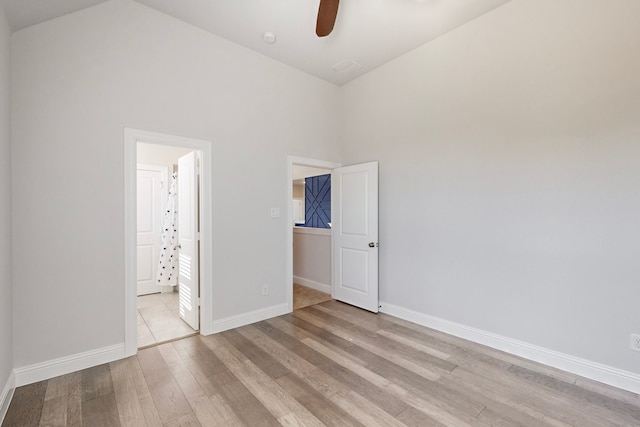 unfurnished bedroom featuring ceiling fan, light hardwood / wood-style flooring, and high vaulted ceiling