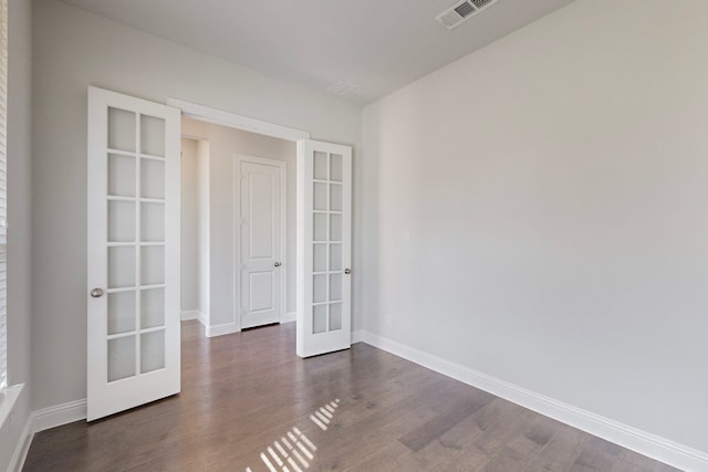 spare room with dark hardwood / wood-style flooring and french doors