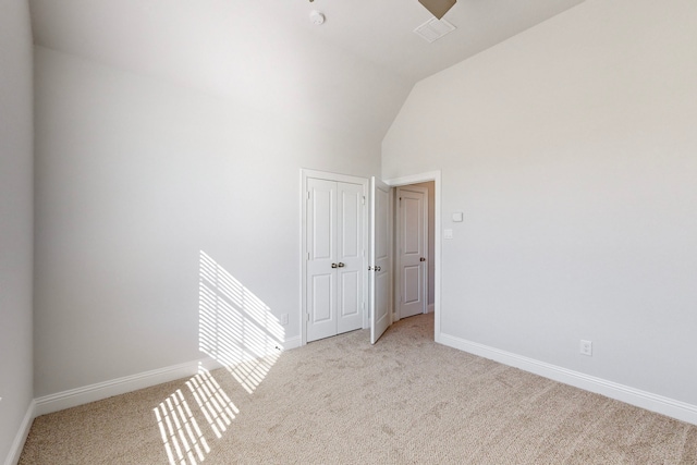 carpeted spare room with vaulted ceiling