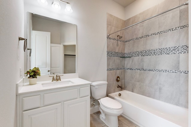 full bathroom with tile patterned flooring, vanity, tiled shower / bath combo, and toilet