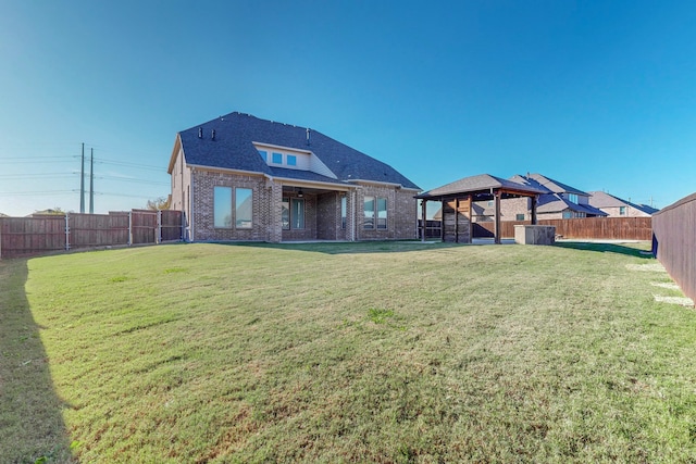 back of house with a gazebo and a yard