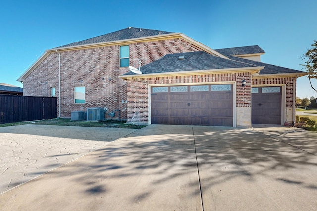 exterior space featuring central air condition unit and a garage