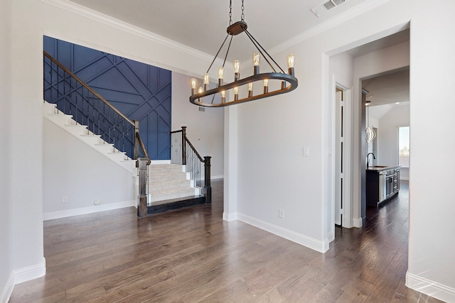 dining space featuring dark hardwood / wood-style floors, crown molding, and sink