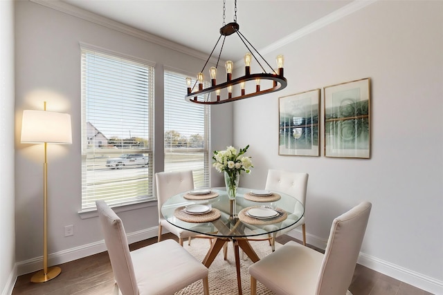 dining space with crown molding, dark hardwood / wood-style flooring, and an inviting chandelier