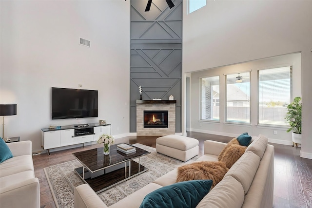 living room featuring ceiling fan, a towering ceiling, and hardwood / wood-style flooring