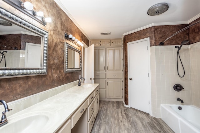 bathroom featuring vanity, ornamental molding, tiled shower / bath combo, and hardwood / wood-style flooring