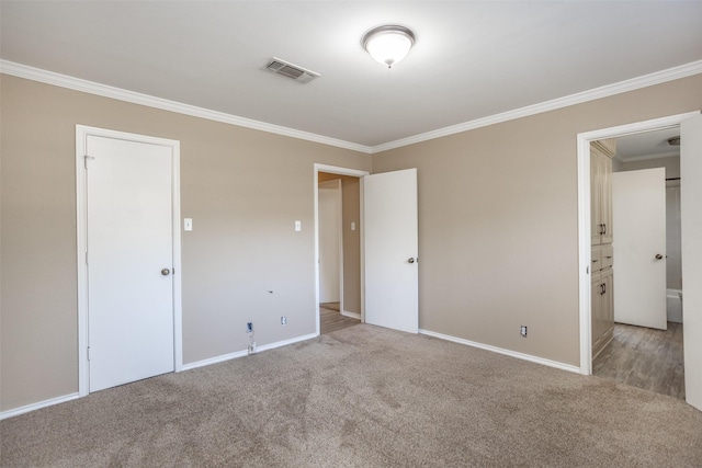 unfurnished bedroom featuring connected bathroom, crown molding, and light colored carpet