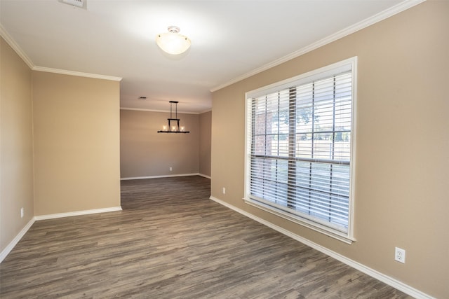 spare room featuring crown molding, dark hardwood / wood-style flooring, and a chandelier