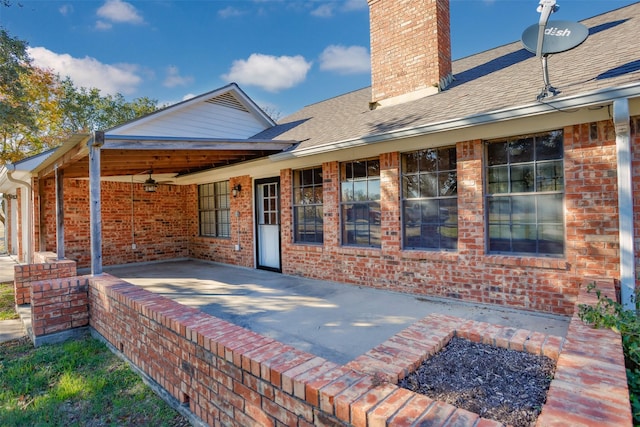 rear view of house with ceiling fan and a patio