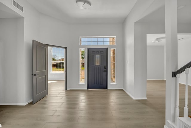 foyer entrance with wood-type flooring and a high ceiling